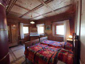 a bedroom with a bed in a wooden room at Im Laret, Lavin in Zernez +10 photos