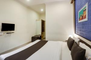 a bedroom with a white bed and a tv at Super Capital O Prestige in Hyderabad