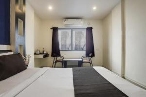 a bedroom with a bed and a table and chairs at Super Capital O Prestige in Hyderabad +22 photos