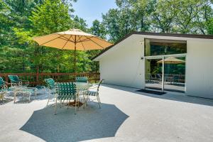 a patio with a table and chairs and an umbrella at Trail Access On-Site: Gorgeous MCM Deck House! in Dover