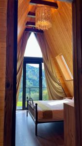 a bedroom with a canopy bed with a large window at Mtis Racha in Oni