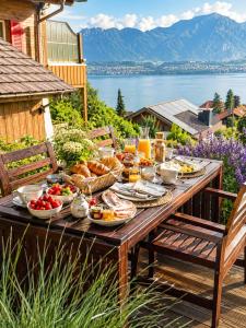 a picnic table with food on it with a view of the water at Mon Bijou Chalet au Lac Alpin in Thun