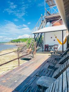a wooden deck with a hammock on a beach at Chalé Mar Aberto in Atins