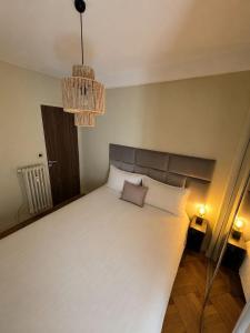 a bedroom with a large white bed with two pillows at Un balcon sur la mer in Nice