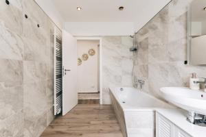 a white bathroom with a sink and a tub at Altmarkt Palais in Löbau +22 photos