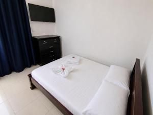 a bedroom with a bed and a dresser with a flower on it at Casa hostal la herradura in San Vicente de Chucurí