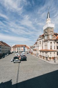 a town with a clock tower and cars parked in a parking lot at Altmarkt Palais in Löbau