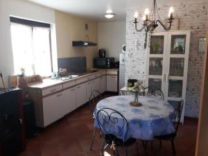 a kitchen with a table with a blue table cloth at Les Six Vallées in Ramillies