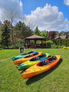 a group of kayaks sitting on the grass in a field at Dom Nad Wodą - Smolarnia in Smolarnia