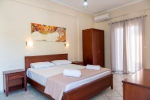 a bedroom with a bed with two white towels on it at NIKOS DIMAS STUDIOS in Parga