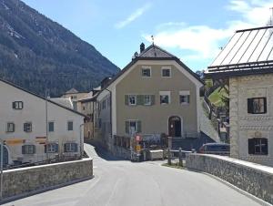 a street in a town with buildings and a mountain at Im Laret, Lavin in Zernez