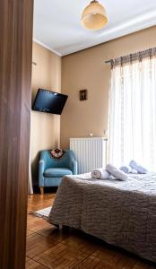 ein Schlafzimmer mit einem Bett und einem blauen Stuhl in der Unterkunft Dinis Hill in Tragána