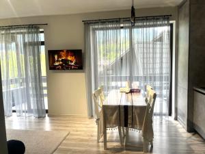 a dining room with a table and a fireplace at Mountain Stream Serenity - AC and Free Parking in Buşteni