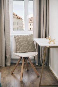 a chair with a pillow on a table in front of a window at Residenz am Altmarkt in Löbau