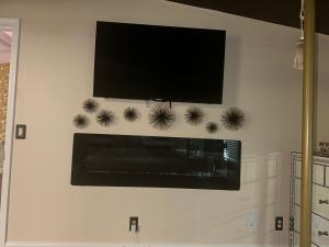 a flat screen tv hanging on a white wall at The Get Away Haven in Stockbridge