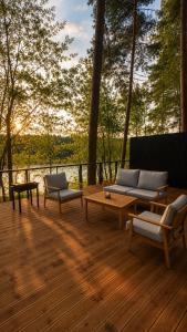 a wooden deck with couches and a table and chairs at Aura Glemp & SPA in Laukbeitini