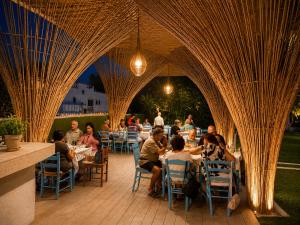 a group of people sitting at tables in an archway at BLACK AMBER BOUTIQUE HOTEL in Lampi