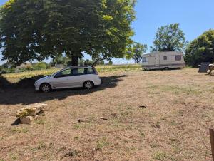 a car parked in a field next to a trailer at Au soleil in Virac