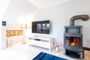 a living room with a fireplace and a tv at Am Horizont 1 lichtdurchflutet modern zentral und ruhig Nähe Strand WLAN und Parkplatz inklusiv in Zingst