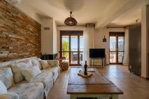 a living room with a white couch and a brick wall at Villa Malvina in Neos Marmaras