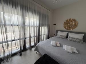 a bedroom with a bed and a large window at The Mulberry House Heritage by the Sea in Alexandroupoli