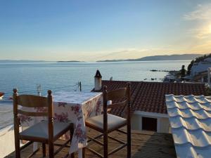 a table and chairs on a balcony with a view of the water at Boat House in Loutraki