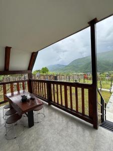 a wooden balcony with a table and a view at Racha Hills in Ambrolauri +22 photos