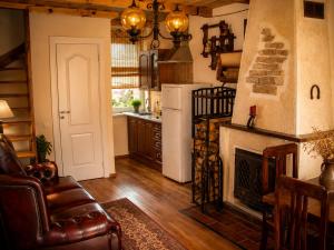 a living room with a fireplace and a kitchen at Adomo Rojus in Palanga