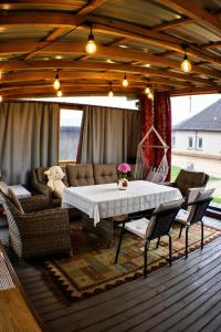 a patio with a table and chairs on a deck at Aukštupio Vila in Aukštupėnai