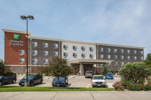 a large building with cars parked in a parking lot at Holiday Inn Express Hastings by IHG in Hastings