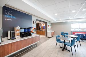 a restaurant with tables and blue chairs and a counter at Holiday Inn Express Hastings by IHG in Hastings