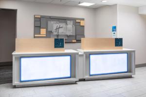 a waiting room with two counters with white screens at Holiday Inn Express Hastings by IHG in Hastings +35 photos