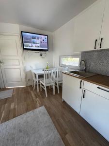 a kitchen with a table and a tv on the wall at Hammar Hus in Kristianstad +5 photos