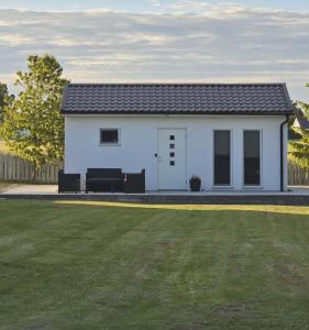 a white tiny house with a large yard at Hammar Hus in Kristianstad