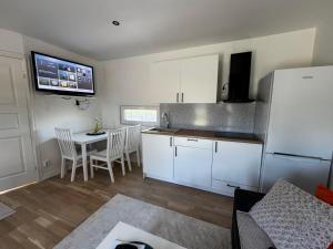 a kitchen with a table and a white refrigerator at Hammar Hus in Kristianstad