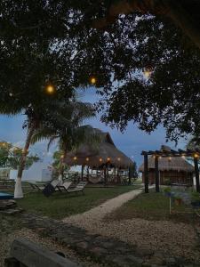 a pavilion with a table and chairs under a tree at Hotel Shalva Barahona in Izamal