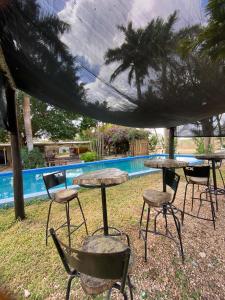 a group of tables and chairs next to a pool at Hotel Shalva Barahona in Izamal
