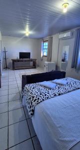 a bedroom with two beds and a piano in the background at Pousada chafariz in Pirenópolis