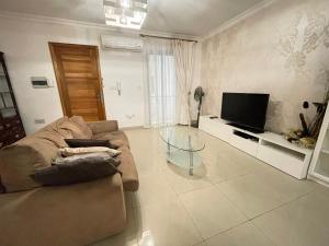 a living room with a couch and a television at sliema promenade in Sliema