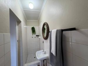 a white bathroom with a sink and a mirror at Accommodation at Klein Street-Blue in Paarl