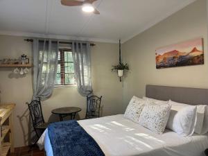 a bedroom with a bed and a table and a window at Accommodation at Klein Street-Blue in Paarl