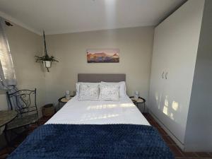 a bedroom with a large bed with a blue blanket at Accommodation at Klein Street-Blue in Paarl +2 photos