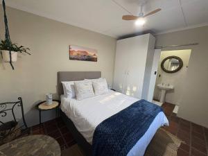 a bedroom with a bed with a blue blanket at Accommodation at Klein Street-Blue in Paarl