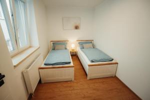 two twin beds in a room with a window at Apartmány u Jeníka in Děčín +32 photos