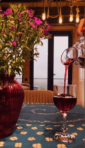 a glass of red wine sitting on a table at Mtis Racha in Oni