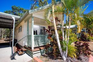 a house with a palm tree in front of it at Discovery Parks - Tannum Sands in Tannum Sands