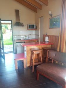 a kitchen with a red counter top and a kitchen with a counter top at Cabañas Lago Sur in Puerto Varas +8 photos