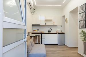a small kitchen with white cabinets and a counter at Charma Urban Living in Bendevís