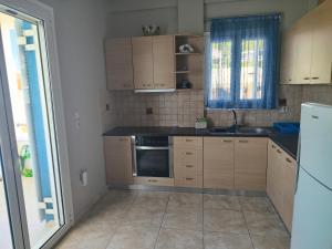 a kitchen with wooden cabinets and a sink at Adam s house in Vaia