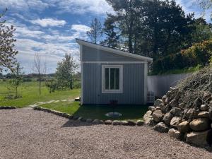 a small grey shed with a gravel yard at The Fäxaåsen cabin in Varberg